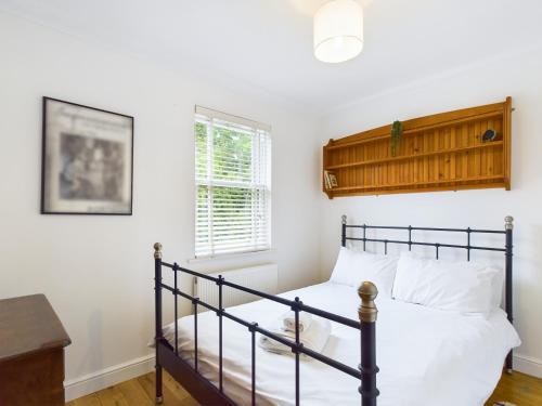 een slaapkamer met een bed en een raam bij Queens Mews a contemporary beach side holiday home for 6 in Ryde