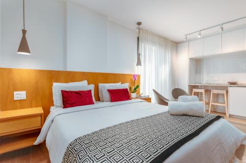 リオデジャネイロにあるUnhotel - Bossa Design Studios Ipanema, Perto da Praiaのベッドルーム1室(大型ベッド1台、赤い枕付)
