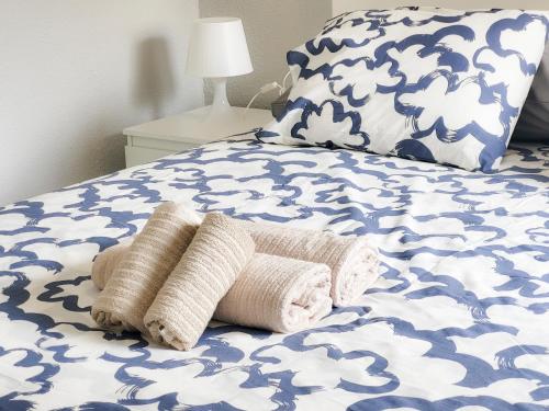 un letto blu e bianco con due asciugamani sopra di Cristimar Roja Beach a Los Cristianos