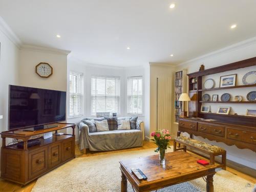 a living room with a couch and a table at Queens Mews a contemporary beach side holiday home for 6 in Ryde