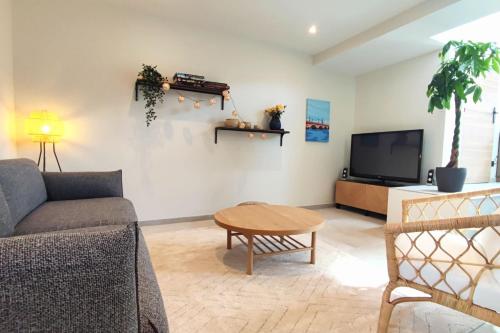 un salon avec un canapé, une table et une télévision dans l'établissement Beautiful house near the Parc Bordelais, à Bordeaux