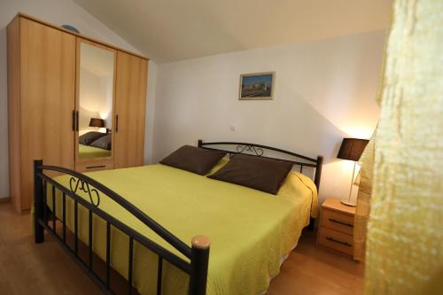1 dormitorio con 1 cama con colcha amarilla en Apartments Salona, en Trogir