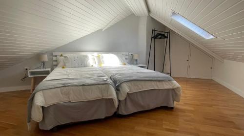 een slaapkamer met een groot bed op een zolder bij CHECK-IN CASAS Casa Benas in Benasque