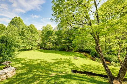 a large green field with a bench and trees at Highlands Cabin on Buck Creek about 8 Mi to Town! in Highlands