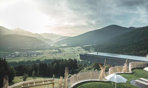 a building with a view of a valley and mountains at Alpin Panorama Hotel Hubertus in Valdaora