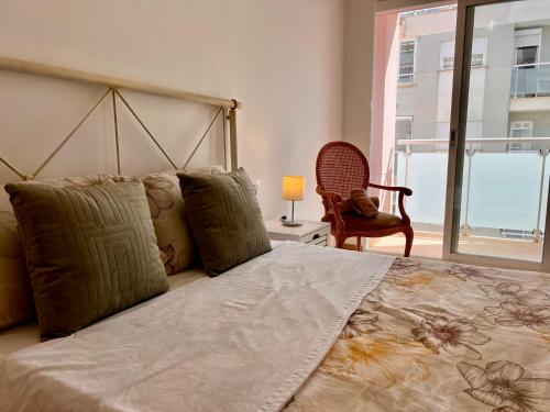 a bedroom with a large bed with a lamp and a chair at Casa Pepa by Sun & Sea Homes in Moraira