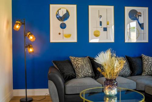 a living room with a couch and a blue wall at Short Stays, Free Parking, Contractors, Families - Large Home in Durham