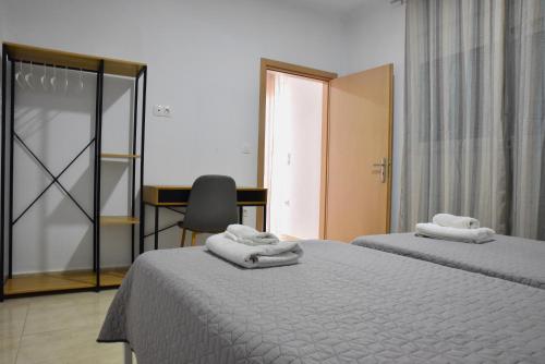 una camera da letto con due letti, una scrivania e una sedia di Roseberry Studios a Faliraki