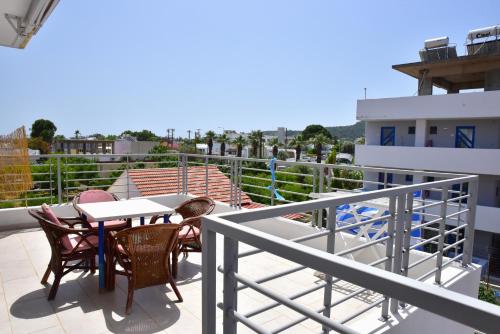 Un patio con una mesa y sillas en un balcón. en Roseberry Studios, en Faliraki
