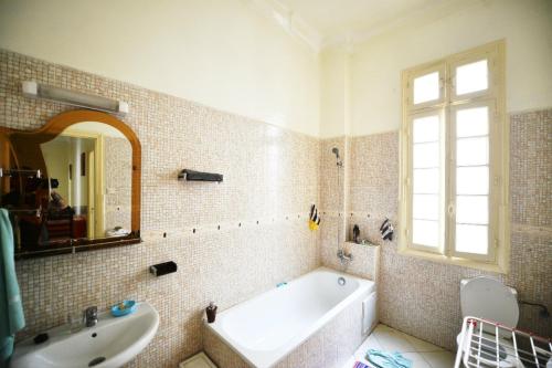 La salle de bains est pourvue d'une baignoire, d'un lavabo et d'un miroir. dans l'établissement Cosy Art Deco Apart, à Casablanca