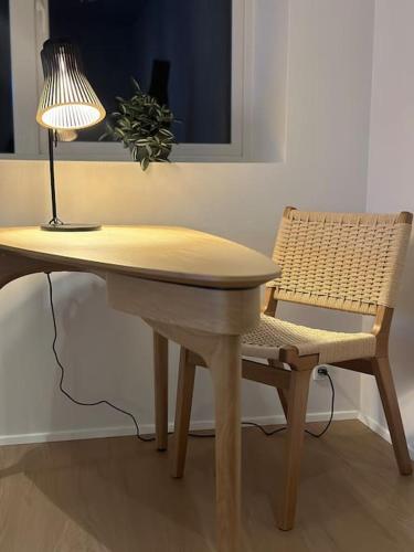 a table and a chair with a lamp and a table and a lamp at Faroe Stay Apartments No 3 in Tórshavn