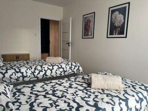 a bedroom with two beds and two pictures on the wall at Apartament Amelium Darmowy podziemny parking in Suwałki