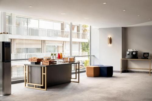 a living room with a table and a large window at Le Meridien Nice in Nice