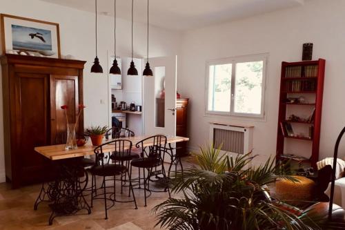 ein Wohnzimmer mit einem Tisch, Stühlen und einem Fenster in der Unterkunft Charming House Ideally Located With Furnished Terrace 3 Bedrooms & Parking in Le Bouscat