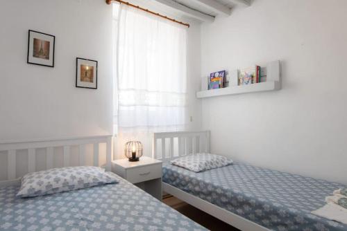 a bedroom with two beds and a window at Sunrise balcony in Sifnos