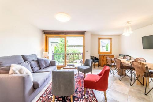 a living room with a couch and a table and chairs at 3-bedroom flat in the city centre in Chamonix