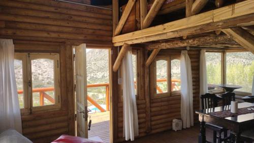 a room with wooden walls and windows in a cabin at Cabaña Rincón del Sol in Potrerillos