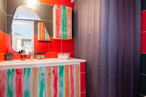 a colorful bathroom with a sink and a mirror at Sunrise balcony in Sifnos