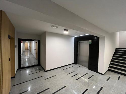 an empty hallway with stairs and a white wall at Apartament Amelium Darmowy podziemny parking in Suwałki