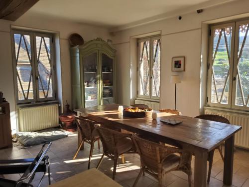 een eetkamer met een houten tafel en stoelen bij La Parenthèse à Etrigny in Étrigny
