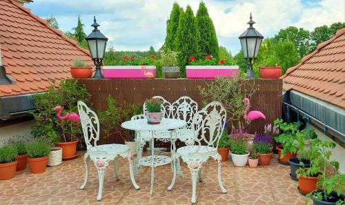 um pátio com mesas, cadeiras e vasos de plantas em DOM GOŚCINNY NAD JEZIOREM BIAŁYM em Gorzewo