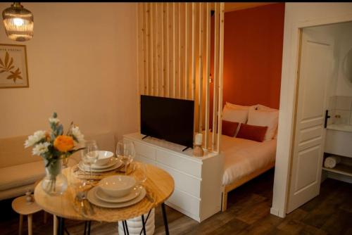 une chambre avec un lit et une table avec une télévision dans l'établissement Studio la halte ducale #2, à Charleville-Mézières