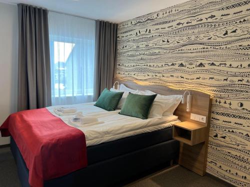 a hotel room with a bed with a wall at Arctic Hotel Nordkapp in Honningsvåg