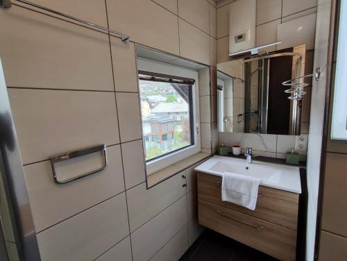 a small bathroom with a sink and a window at Alpinoase City Centre Zell am See in Zell am See