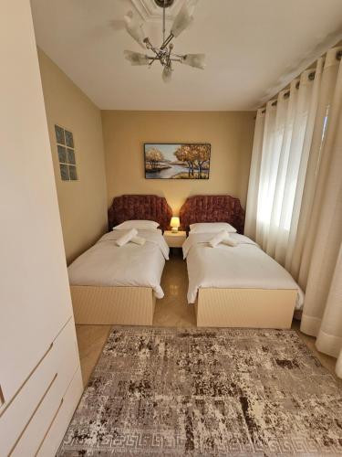 a bedroom with two beds and a window at Linda's Guest House in Berat