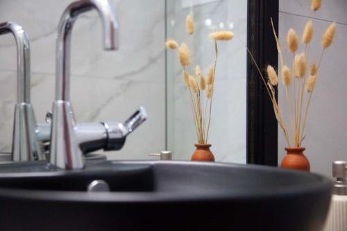 a bathroom sink with two vases with flowers in it at Villa Primarosa in Metaxáta