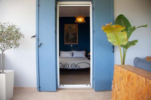um quarto com paredes azuis e uma cama através de uma porta em Villa Primarosa em Metaxáta