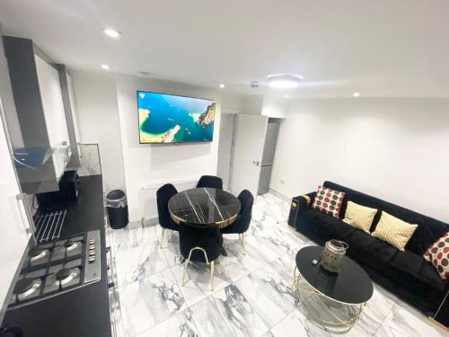a living room with a couch and a table at THE ROYAL BOUTIQUE WESTMINSTER LODGE by LONDON SLEEP 9 in Hayes