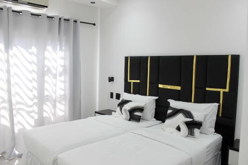two beds in a room with white and black at Esteem guesthouse Windhoek in Windhoek