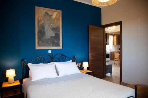 une chambre bleue avec un lit et un tableau mural dans l'établissement Villa Primarosa, à Metaxáta