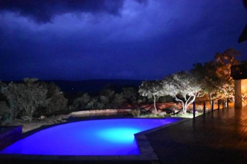a swimming pool at night with blue lighting at Tholo Private Game Lodge in Bela-Bela