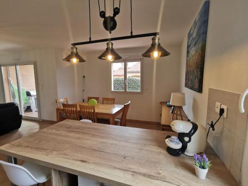 - un salon avec une table en bois et une salle à manger dans l'établissement Appartement La pinède - Tout Confort - Piscine de saison - 2 chambres - Proche plage et Commerces, au Barcarès