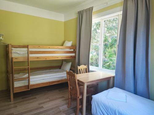 a bedroom with a desk and a bunk bed and a table at Lainela puhkeküla in Käsmu