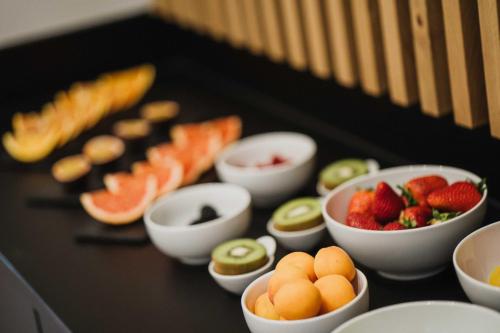 una tabella ricoperta di ciotole di frutta e verdura di Thalguter - Rooms & Breakfast a Lagundo