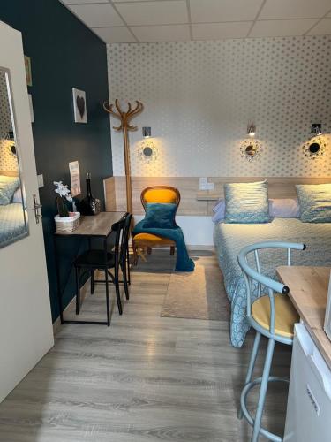 une chambre avec un lit, une table et des chaises dans l'établissement Résidence Sainte Thérèse - la villa Selva, à Lourdes