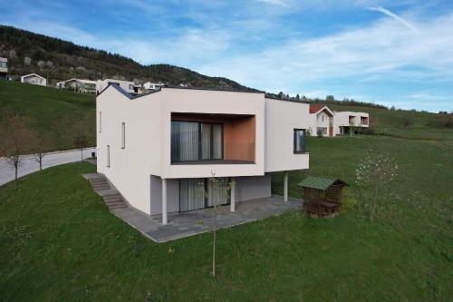 a white house on top of a green field at Poljine Hills in Poljine