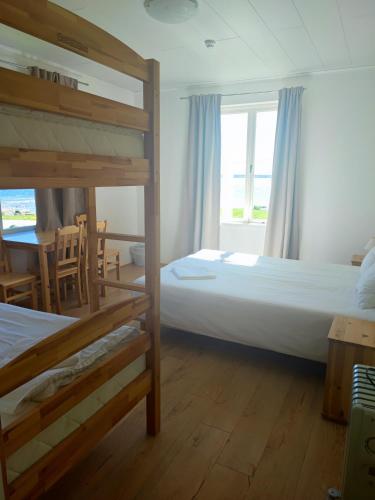 a bedroom with two bunk beds and a table at Lainela puhkeküla in Käsmu