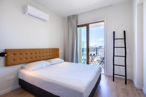 a bedroom with a bed and a balcony with a ladder at STAY Cityscape Charm in Nicosia