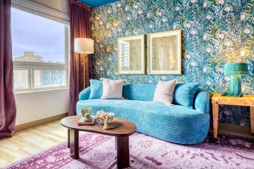 a living room with a blue couch and floral wallpaper at Quest Travels in Seattle
