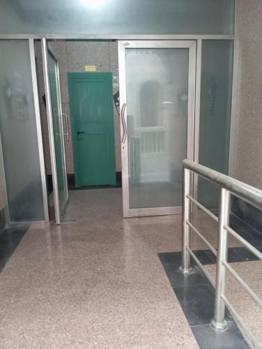 korytarz z zielonymi drzwiami w budynku w obiekcie Booking to preferred room w Szardży