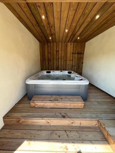 a bath tub in a room with a wooden ceiling at Maison Au Bout Du Pre in Goulven