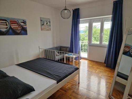 a bedroom with a bed and a large window at Apartment Elena in Dramalj