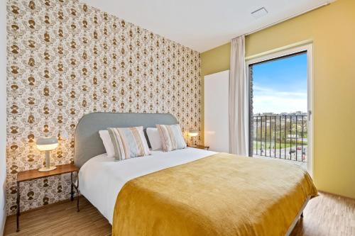 - une chambre avec un grand lit et une fenêtre dans l'établissement Boutique Hollerich Apartment, à Luxembourg