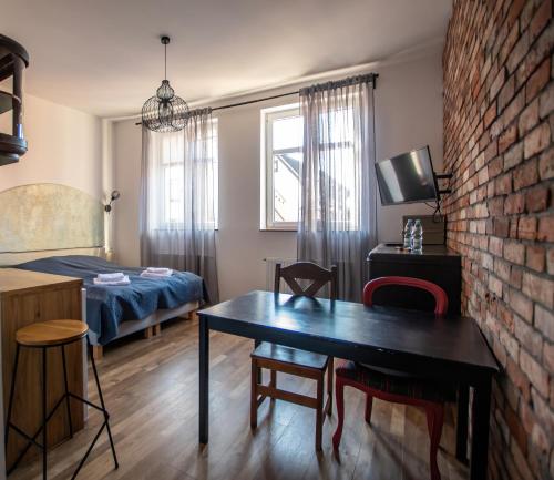 a small room with a table and a bed at Apartamenty w Ścieżce Kościelnej in Elblag