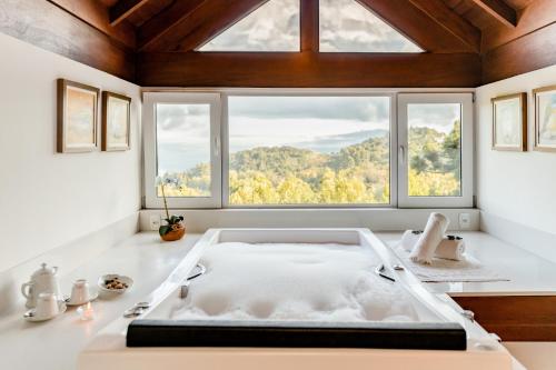 a bath tub in a room with a window at Hotel Jardins da Colina in Nova Petrópolis
