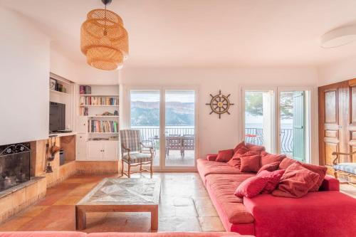 - un salon avec un canapé rouge et une cheminée dans l'établissement Le Panorama de Cassis - Welkeys, à Cassis